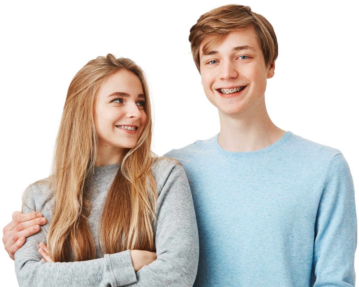 teen boy and a teen girl with braces laugh and hug after orthodontic treatment in Village Ortho