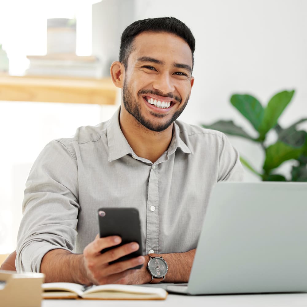 adult male smiling in his office after getting Airway Orthodontics Treatment for Adults