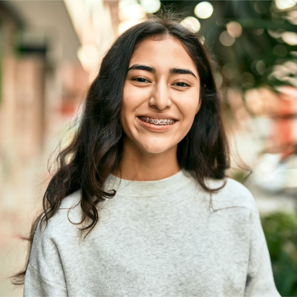 A girl with orthodontic braces smiling