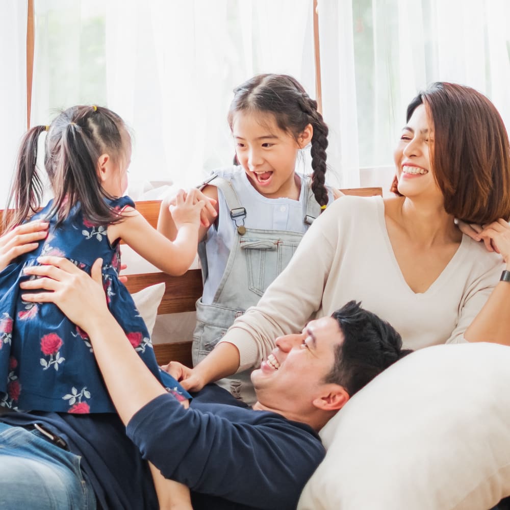 happy family smiling and playing together after their visit to Village Orthodontics in Ontario