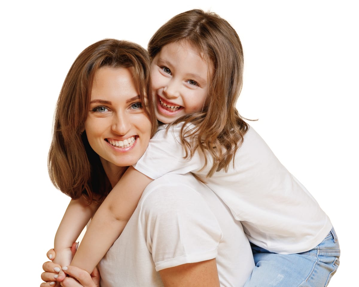 mother and young daughter hug and smile after daughter had interceptive orthodontic treatment